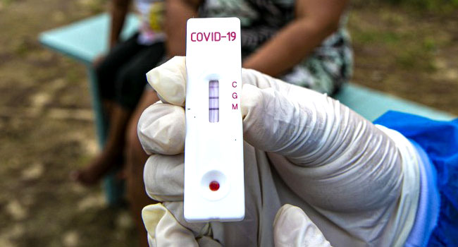 A file photo of a healthcare worker holding a COVID-19 test kit. TARSO SARRAF / AFP