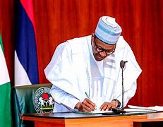 File image of President Muhammadu Buhari, signing a document